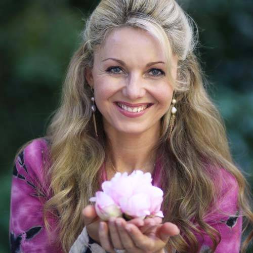 Miranda Macpherson holding a beautiful, pink flower blossom, probably lotus